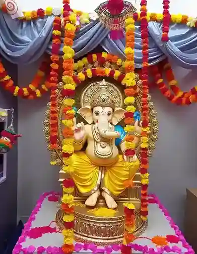 Ganpati decoration with marigold and red roses, featuring a majestic idol with a golden backdrop | Vibrant Ganpati Flower Decoration with Marigold and Red Roses | Ganesh Chaturthi Decorations | Decorations Guru